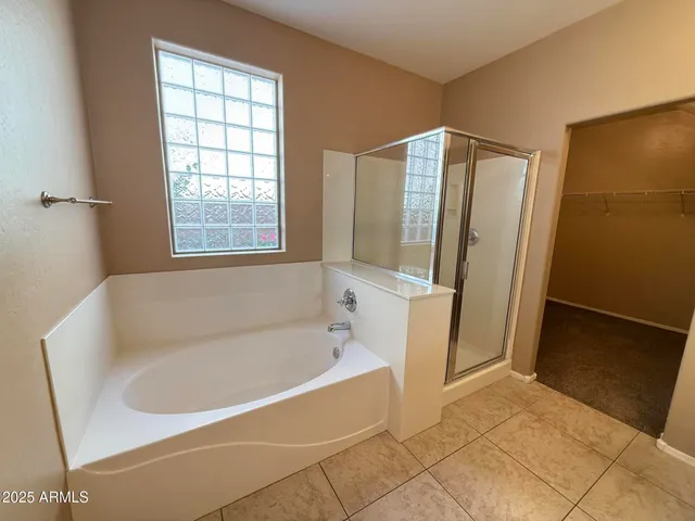 a white bath tub sitting in a bathroom next to a window