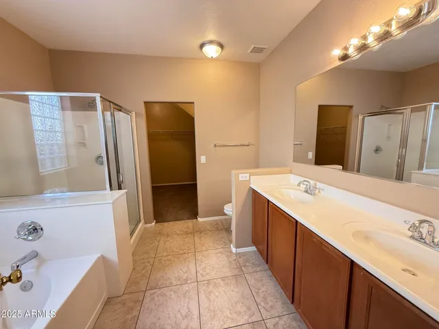 a spacious bathroom with a tub sink and a mirror