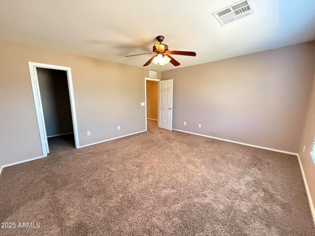 an empty room with a window and a ceiling fan