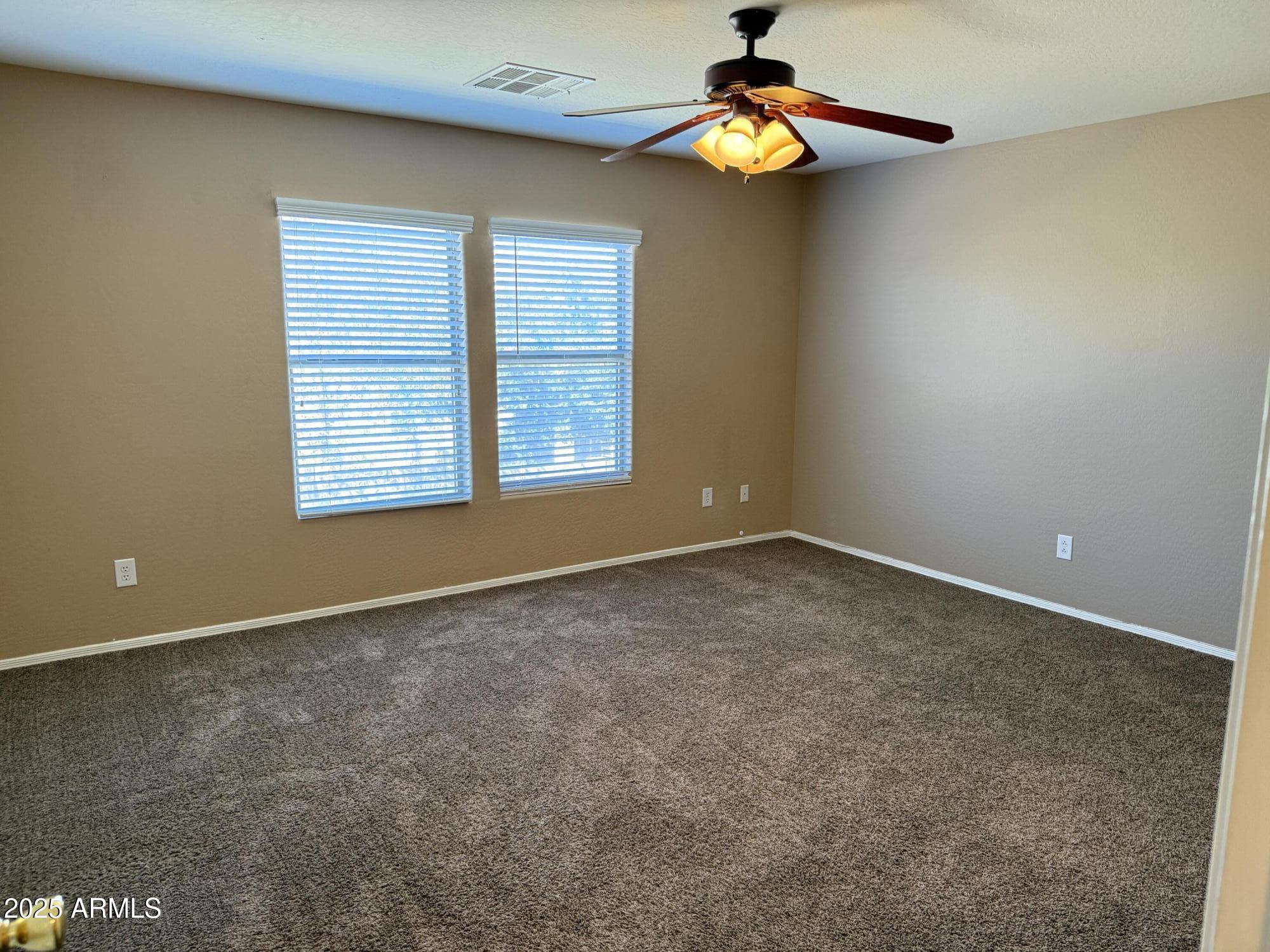 11752 West Foothill Drive Sun City, AZ 85373 - Photo 36 of 48 an empty room with a window and a chandelier fan