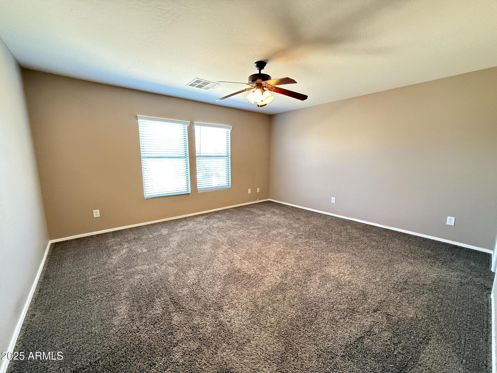 11752 West Foothill Drive Sun City, AZ 85373 - Photo 37 of 48 an empty room with windows and chandelier fan