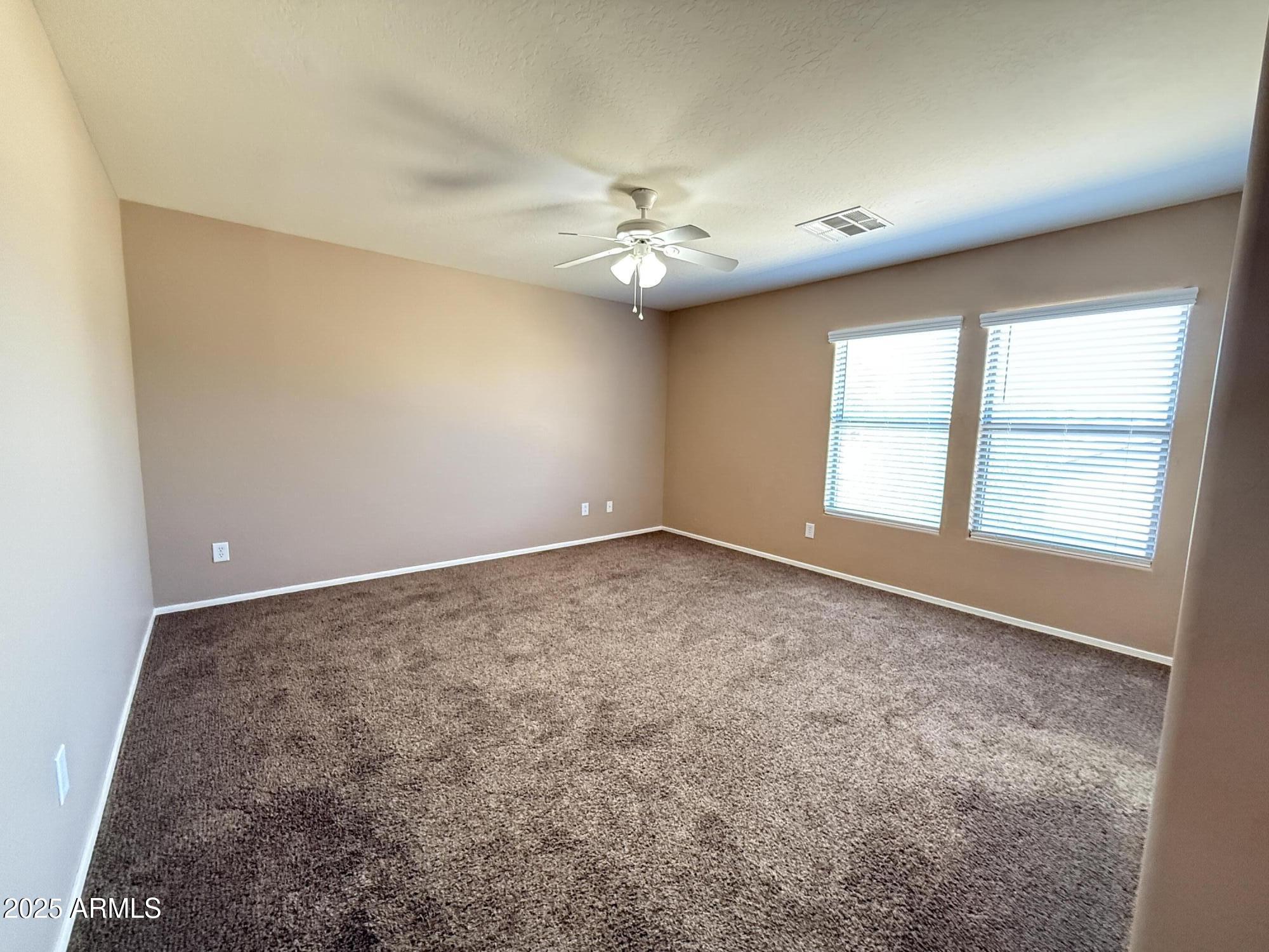 11752 West Foothill Drive Sun City, AZ 85373 - Photo 39 of 48 an empty room with a window and ceiling fan