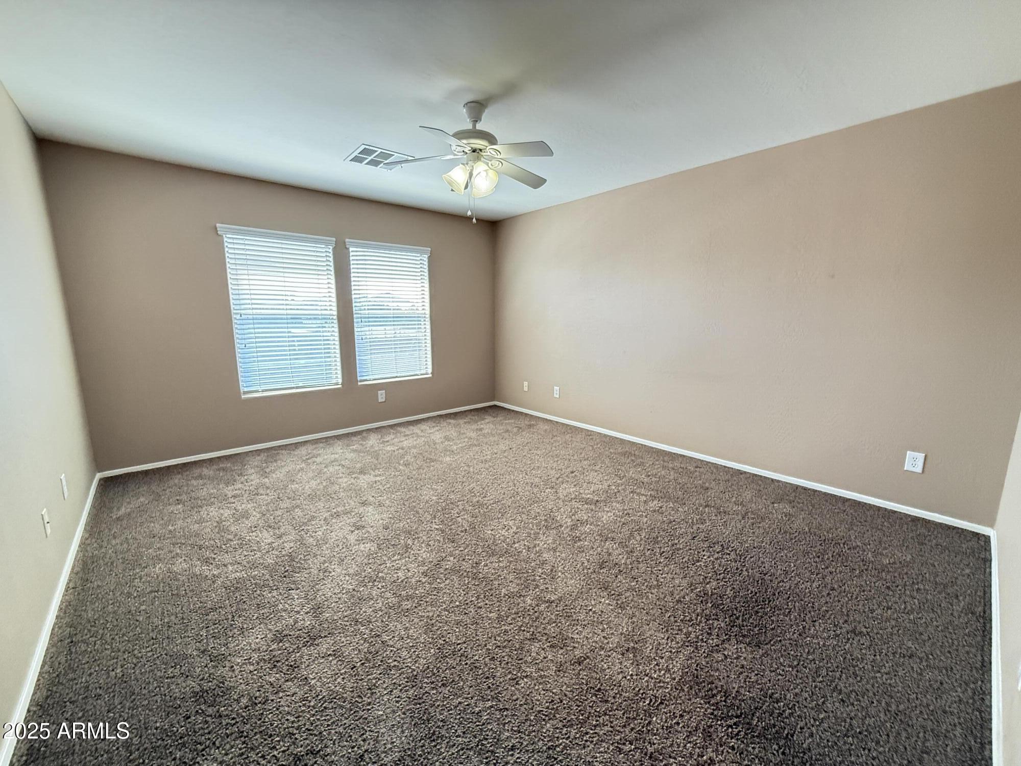 11752 West Foothill Drive Sun City, AZ 85373 - Photo 43 of 48 an empty room with windows and chandelier fan