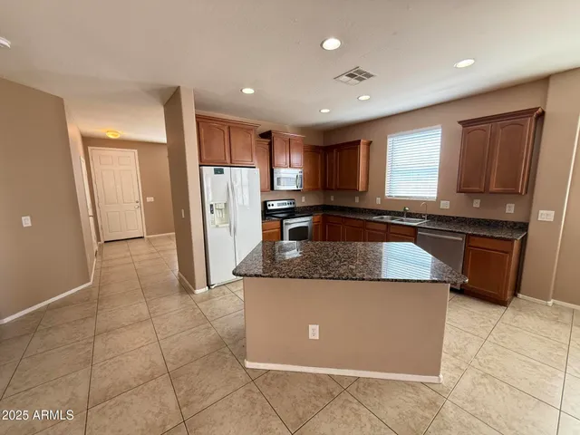 a kitchen with stainless steel appliances granite countertop a refrigerator and a stove