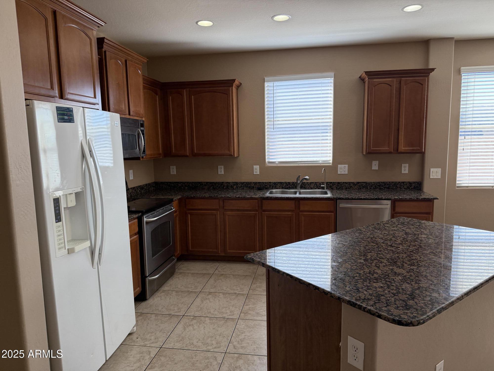 11752 West Foothill Drive Sun City, AZ 85373 - Photo 8 of 48 a kitchen with stainless steel appliances granite countertop a sink stove and refrigerator