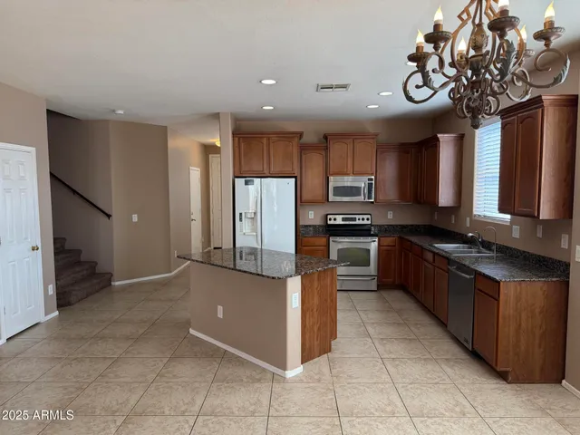a kitchen with stainless steel appliances granite countertop a refrigerator and a sink