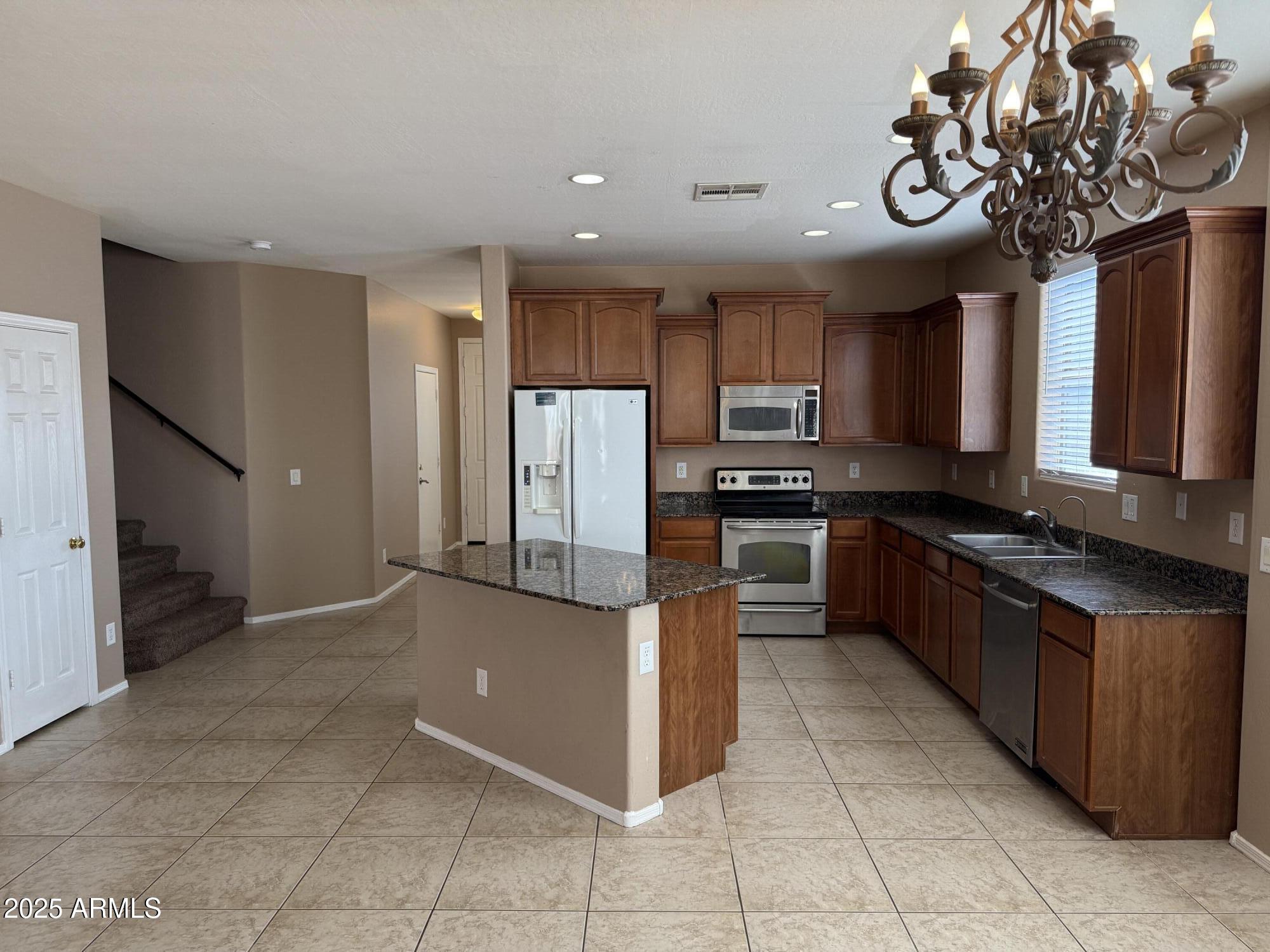 11752 West Foothill Drive Sun City, AZ 85373 - Photo 9 of 48 a kitchen with stainless steel appliances granite countertop a refrigerator and a sink