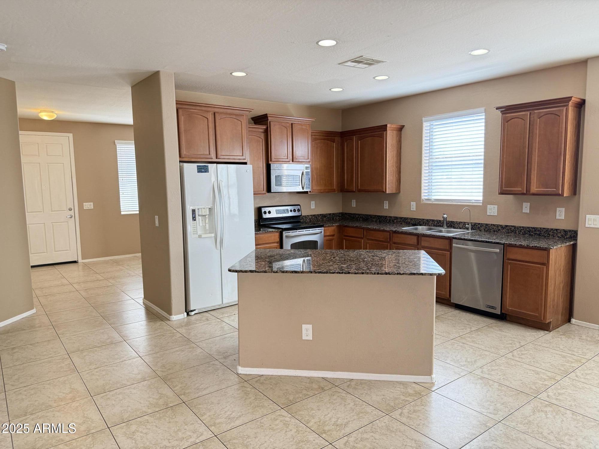 11752 West Foothill Drive Sun City, AZ 85373 - Photo 10 of 48 a kitchen with stainless steel appliances granite countertop a stove top oven a refrigerator a sink and a granite counter tops
