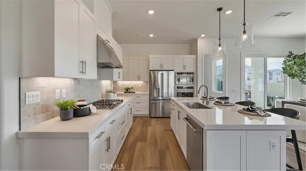 a kitchen with white cabinets and appliances