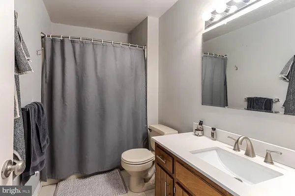 a bathroom with a sink a toilet and shower curtain