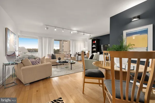 a living room with furniture wooden floor and a large window