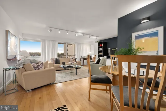 a living room with furniture wooden floor and a large window