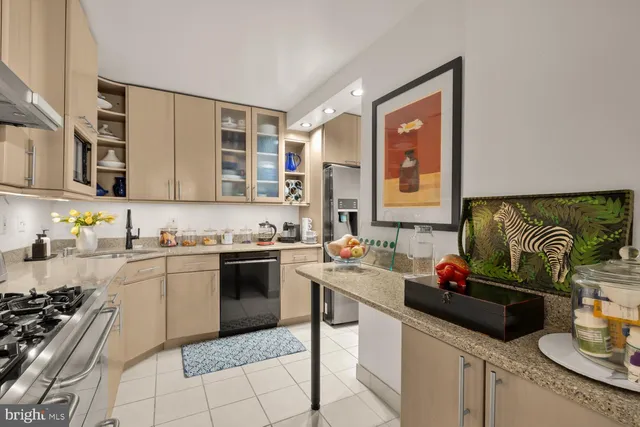 a kitchen with granite countertop stainless steel appliances a stove sink and cabinets