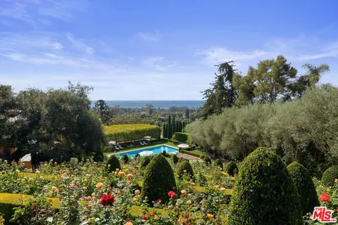 an aerial view of house with yard and trees in the background