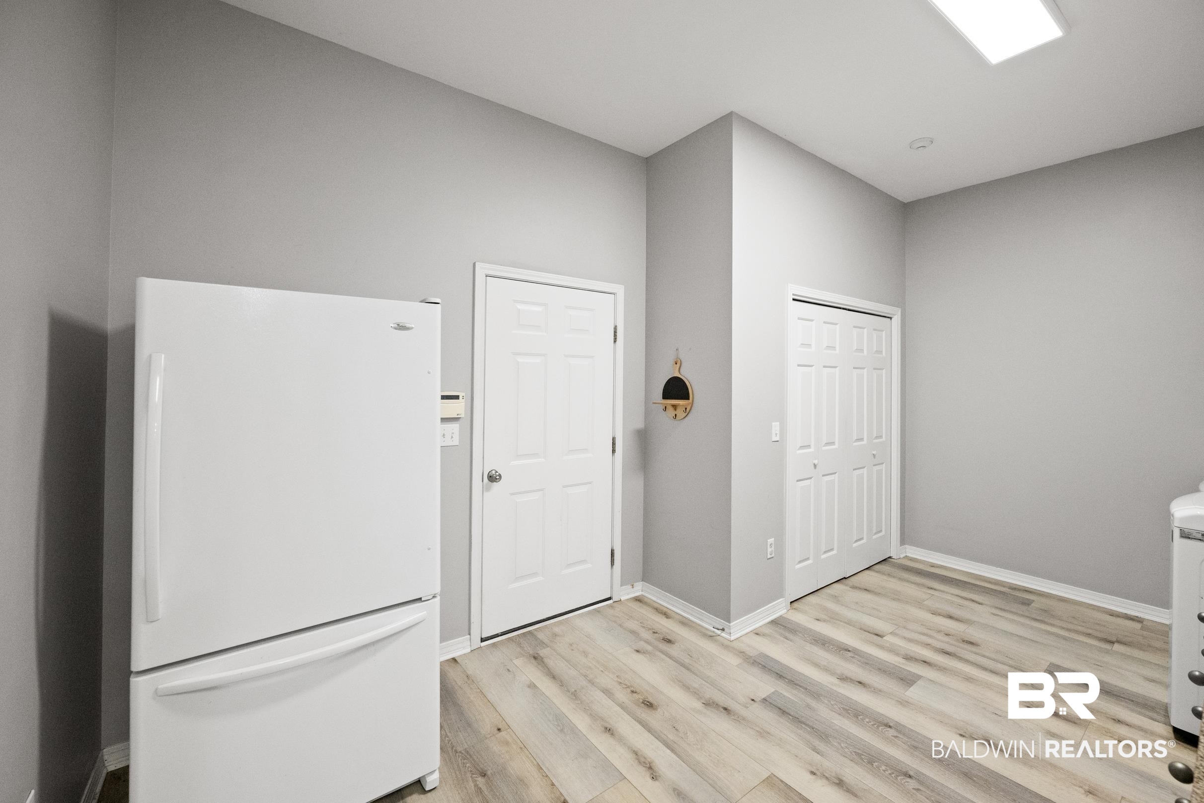 8585 Bay Harbor Road Elberta, AL 36530 - Photo 19 of 51 Laundry area with light wood-style flooring and baseboards