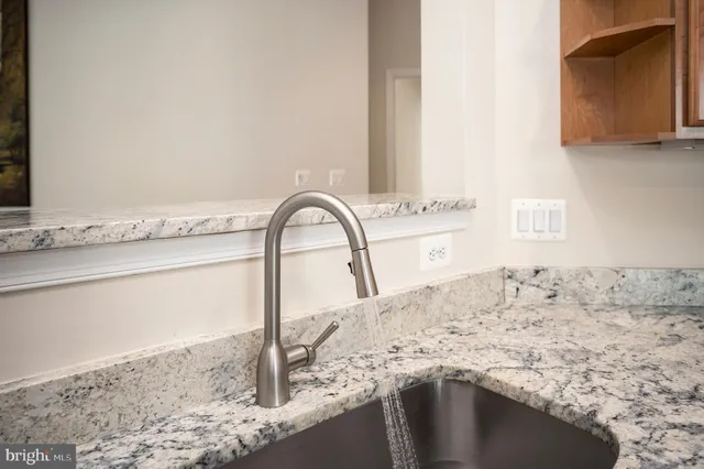 a bathroom with a granite countertop toilet a mirror and a sink