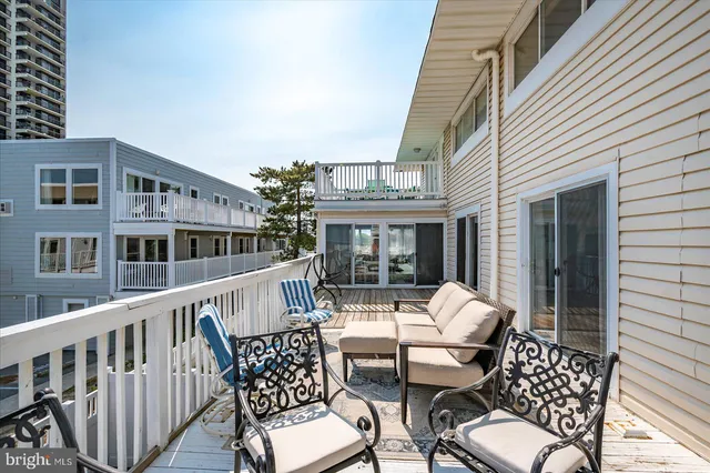 a view of a balcony with a dining table and chairs with wooden floor