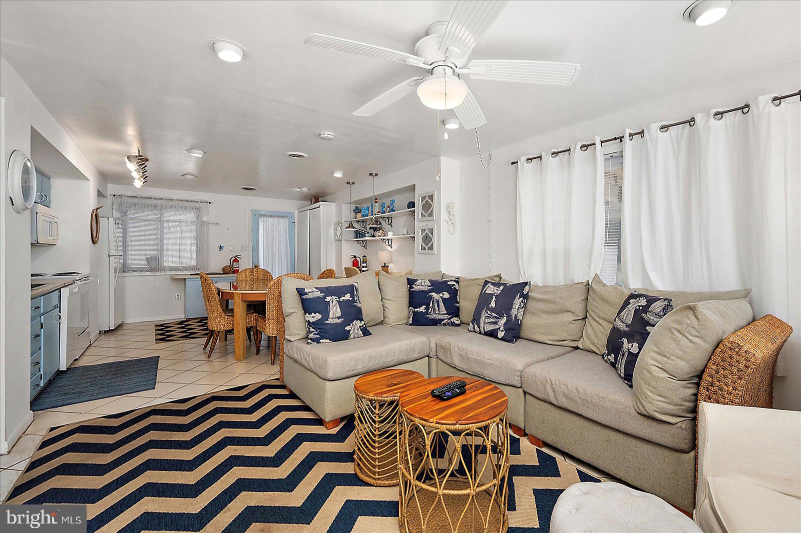 11602 Coastal Highway, Unit 1A Ocean City, MD 21842 - Photo 57 of 83 a living room with furniture a rug and a chandelier