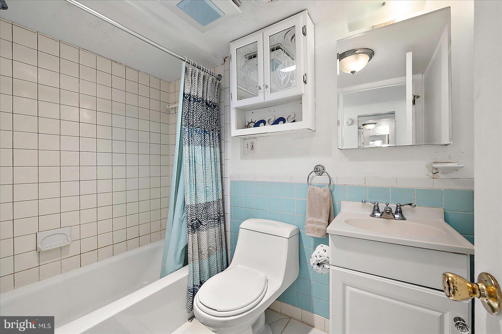 11602 Coastal Highway, Unit 1A Ocean City, MD 21842 - Photo 70 of 83 a white toilet sitting next to a bathroom sink and a tub