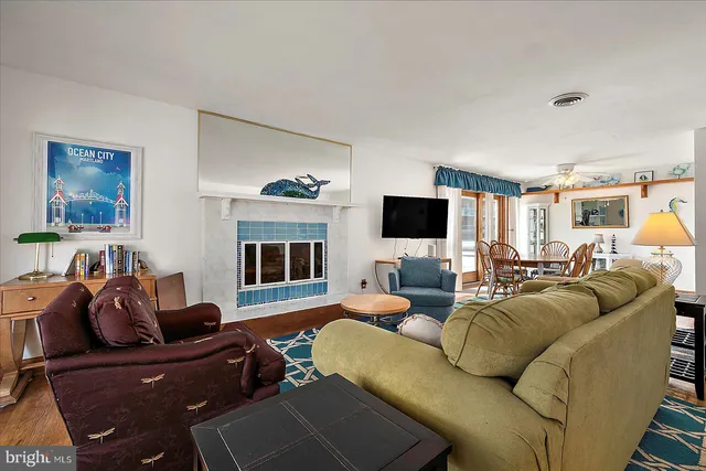 a living room with furniture a flat screen tv and kitchen view