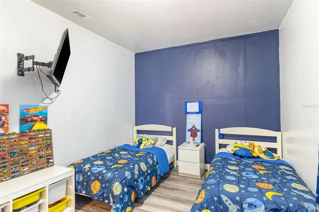 a bedroom with a bed and wooden floor