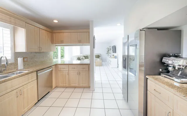 a kitchen with a sink a refrigerator and cabinets