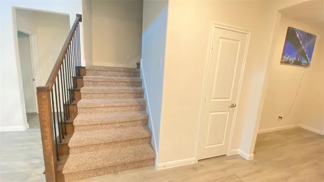 a view of a hallway with wooden floor and entryway