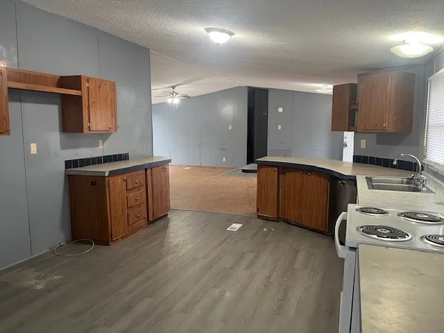 a kitchen with stainless steel appliances granite countertop a stove a sink and a refrigerator