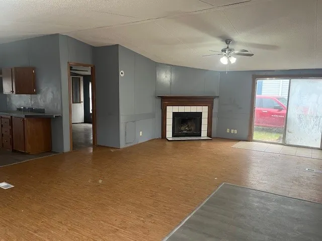 an empty room with windows and fireplace