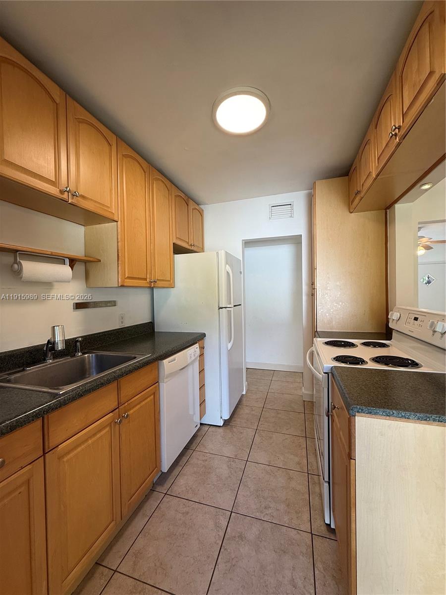 6141 Southwest 47th Street, Unit 1 Miami, FL 33155 - Photo 7 of 11 a kitchen with stainless steel appliances granite countertop a sink stove and refrigerator