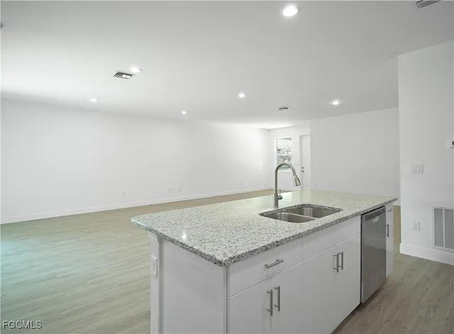a kitchen with granite countertop a refrigerator stove and sink