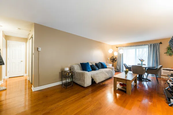 a living room with furniture and a wooden floor
