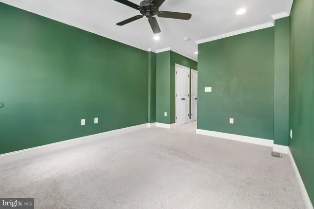 a view of a room with a projector and ceiling fan