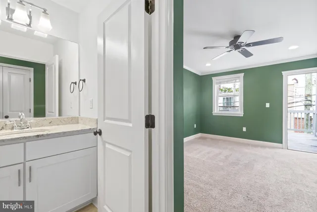 a en suite bathroom with a granite countertop sink a mirror and a shower