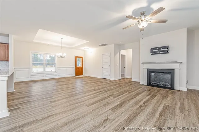a view of empty room with wooden floor and fireplace