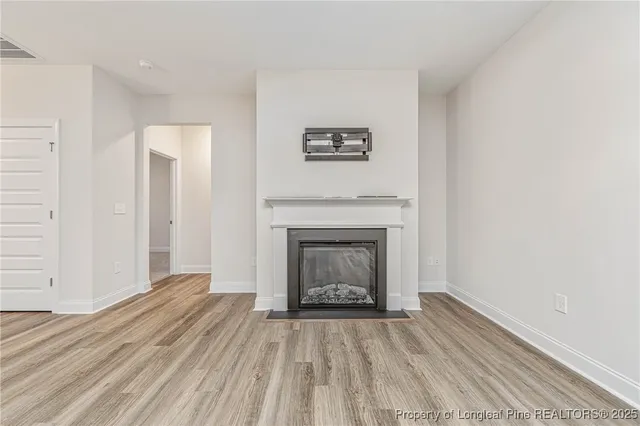a view of a livingroom with wooden floor and a fireplace