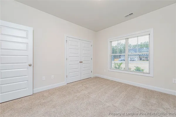 an empty room with windows and closet