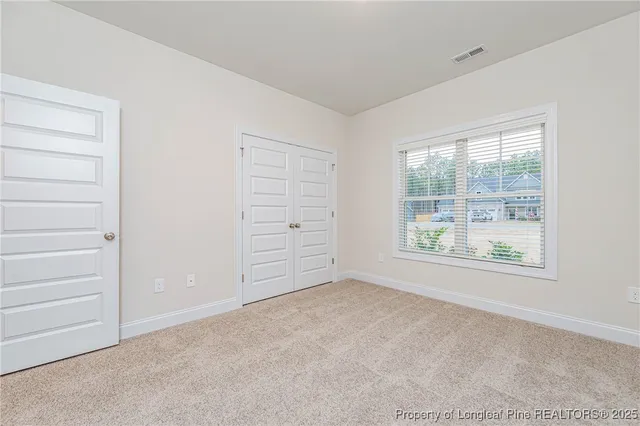 an empty room with windows and closet