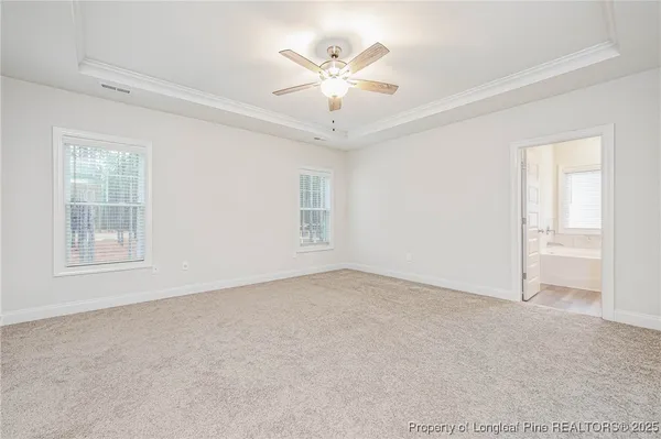 an empty room with windows and ceiling fan