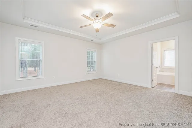an empty room with windows and ceiling fan