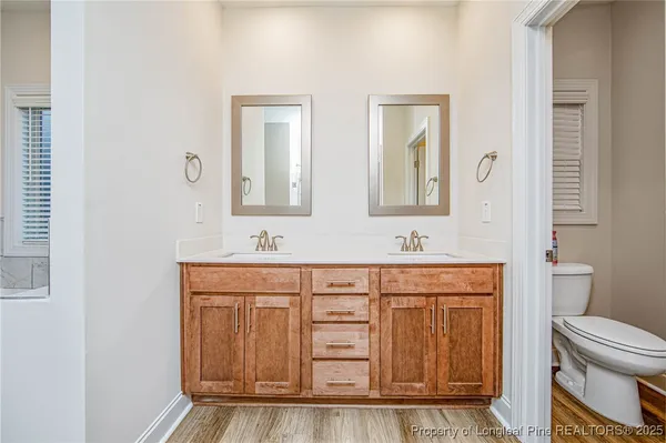 a bathroom with a sink a toilet and a mirror