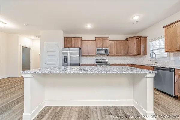a kitchen with stainless steel appliances granite countertop a sink and a stove