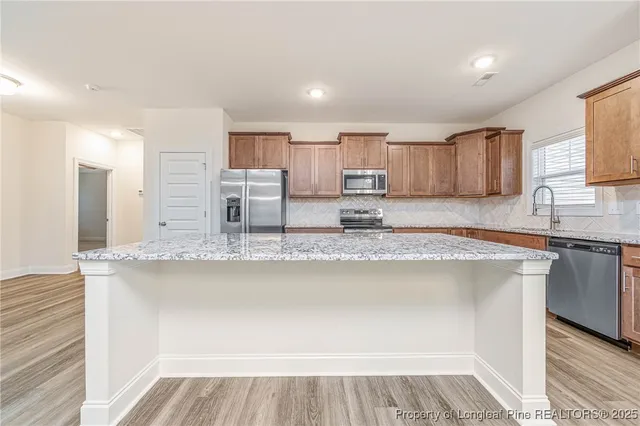 a kitchen with stainless steel appliances granite countertop a sink and a stove
