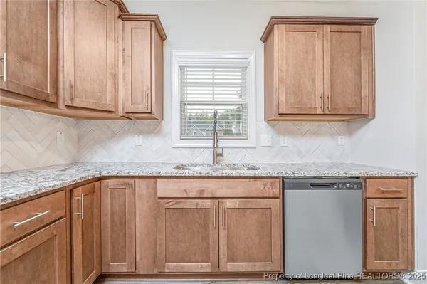 a kitchen with granite countertop cabinets and window