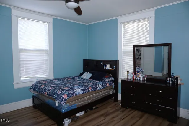 a bedroom with a bed and a mirror on dresser