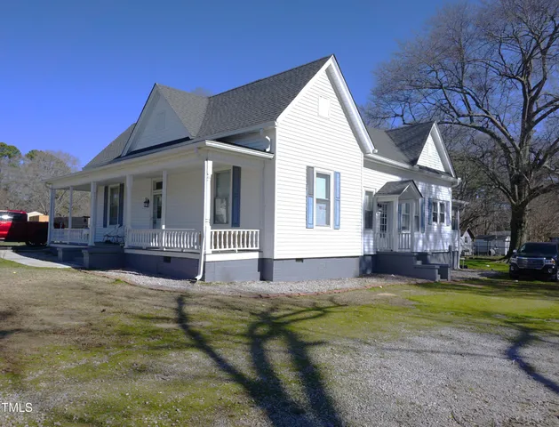 a view of house with yard and tree in front of it