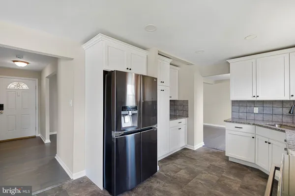 a kitchen with a refrigerator sink and cabinets