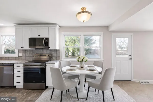 a view of a kitchen with a sink a microwave and cabinets