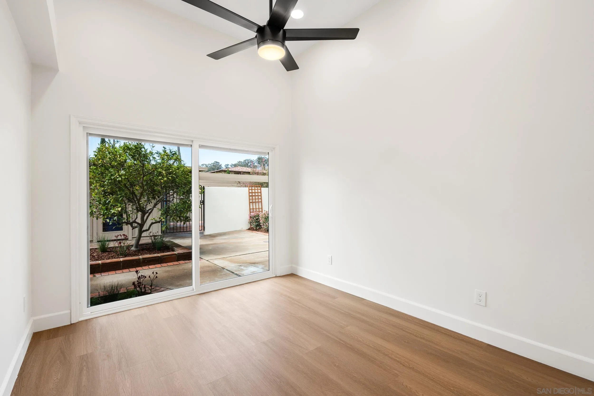 103 Cancha De Golf Rancho Santa Fe, CA 92091 - Photo 19 of 32 an empty room with wooden floor and windows