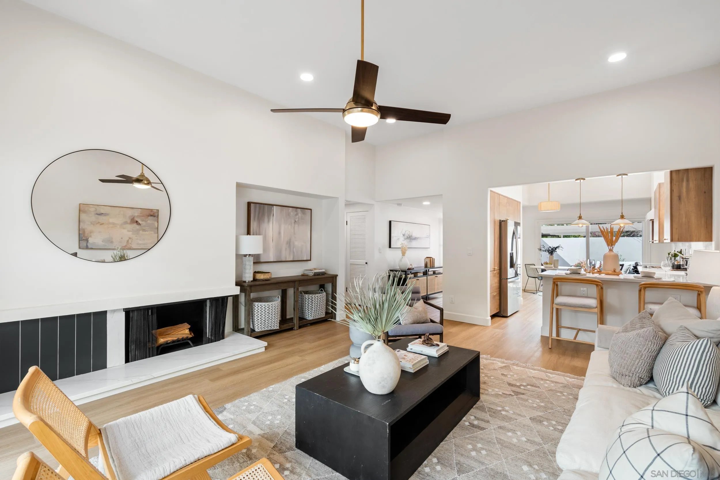 103 Cancha De Golf Rancho Santa Fe, CA 92091 - Photo 5 of 32 a living room with furniture a fireplace and a large mirror